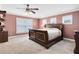 Large main bedroom featuring a ceiling fan, neutral carpeting, and plenty of natural light at 613 Crownclover Ave, Orlando, FL 32828