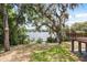 A home's backyard with lush greenery, mature trees, and access to a serene water view from the wood deck at 613 Lake Ave, Altamonte Springs, FL 32701