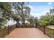 A wood deck overlooks the water, offering a tranquil view surrounded by trees covered with Spanish moss at 613 Lake Ave, Altamonte Springs, FL 32701