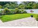 Landscaped backyard features a well-maintained lawn, tasteful plantings, brick paver patio, and a white vinyl fence at 62 Polermo Ave, St Cloud, FL 34771
