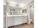 Bright bathroom featuring a double sink vanity with modern fixtures and wood-look flooring at 62 Polermo Ave, St Cloud, FL 34771
