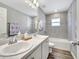 Well-lit bathroom with a double sink vanity, large mirror, and tiled shower/tub combination at 62 Polermo Ave, St Cloud, FL 34771