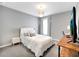 Bedroom showcasing a queen bed, white upholstered headboard, and a gray color scheme at 62 Polermo Ave, St Cloud, FL 34771