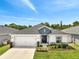 Charming single-story home featuring a manicured lawn, two-car garage, and inviting front entrance at 62 Polermo Ave, St Cloud, FL 34771