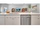 Spacious kitchen island featuring a stainless steel dishwasher, white cabinets, and quartz countertops at 62 Polermo Ave, St Cloud, FL 34771