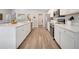 Bright kitchen featuring white cabinets, stainless steel appliances, and a long island with a sink at 62 Polermo Ave, St Cloud, FL 34771