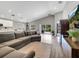 Open-concept living room with a comfortable sectional couch, flowing to the kitchen and outdoor patio at 62 Polermo Ave, St Cloud, FL 34771