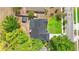 Aerial view of the home features a dark roof, surrounding trees, and neighborhood at 7025 Hiawassee Oak Dr, Orlando, FL 32818