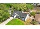 Aerial view of charming home with lush landscaping, dark roof, and fenced yard at 7025 Hiawassee Oak Dr, Orlando, FL 32818