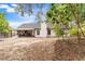 Spacious backyard with covered patio, grill, and mature trees offers privacy at 7025 Hiawassee Oak Dr, Orlando, FL 32818