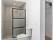 Tiled bathroom with a toilet, frosted glass shower, and closet at 7025 Hiawassee Oak Dr, Orlando, FL 32818