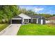 Charming single Gathering home features a manicured lawn, gray accent walls, and a 2-car garage at 7025 Hiawassee Oak Dr, Orlando, FL 32818