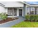 A welcoming front porch features black framed windows, gray brick accents, and professional landscaping at 7025 Hiawassee Oak Dr, Orlando, FL 32818