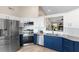 Updated kitchen features two-tone cabinets, stainless steel appliances, granite countertops and a pass-through window at 7025 Hiawassee Oak Dr, Orlando, FL 32818