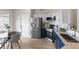 Well-lit kitchen with stainless steel appliances, granite countertops, and white and blue cabinets at 7025 Hiawassee Oak Dr, Orlando, FL 32818