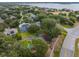 Aerial shot featuring a tennis court with surrounding lush greenery and neighborhood homes at 709 Strihal Loop, Oakland, FL 34787