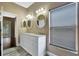 Bright bathroom with a double vanity, oval mirrors and modern lighting fixtures at 709 Strihal Loop, Oakland, FL 34787