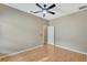 A bedroom with a ceiling fan, wood flooring and a white door at 709 Strihal Loop, Oakland, FL 34787