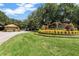 Well-maintained gated community entrance featuring lush greenery and welcoming signage at 709 Strihal Loop, Oakland, FL 34787