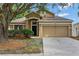 Charming home featuring manicured landscaping, a two-car garage, and a welcoming front entrance at 709 Strihal Loop, Oakland, FL 34787