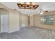 Spacious living room featuring neutral walls, carpet flooring, ceiling fans, and a smooth transition to the kitchen at 709 Strihal Loop, Oakland, FL 34787