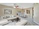 Spacious living room featuring neutral walls, carpet flooring, ceiling fan and an open dining area at 709 Strihal Loop, Oakland, FL 34787