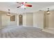 Spacious living room featuring neutral walls, carpet flooring, ceiling fans, and a smooth transition to the kitchen at 709 Strihal Loop, Oakland, FL 34787