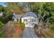 Aerial view showcasing a two-story home with mature trees, a private driveway, and a well-maintained landscape at 7470 Lake Marsha Dr, Orlando, FL 32819