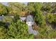 Aerial view of a home in a lush, wooded area with a long driveway and access to a nearby lake at 7470 Lake Marsha Dr, Orlando, FL 32819