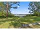 Scenic backyard overlooking a peaceful lake surrounded by lush greenery with a concrete border in the foreground at 7470 Lake Marsha Dr, Orlando, FL 32819