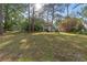 A beautiful backyard featuring green grass, tall trees, and an outdoor grill at 7470 Lake Marsha Dr, Orlando, FL 32819