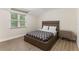 Cozy bedroom features a modern platform bed, contemporary gray finish nightstand and wood flooring at 7470 Lake Marsha Dr, Orlando, FL 32819