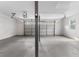 Spacious two car garage with a white block wall, gray floors, a gray support beam, and two windows at 7470 Lake Marsha Dr, Orlando, FL 32819
