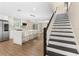 Open-concept kitchen with island seating, stainless steel appliances, and a staircase leading to the second floor at 7470 Lake Marsha Dr, Orlando, FL 32819