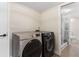 Modern laundry room featuring a new washer and dryer set with a tiled bathroom through a glass door at 7470 Lake Marsha Dr, Orlando, FL 32819
