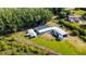 Aerial view of property, house, garages, sheds, and mature trees at 8218 Pine Island Rd, Clermont, FL 34711