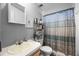 Functional bathroom with a sink, toilet, and shower with a patterned curtain at 8218 Pine Island Rd, Clermont, FL 34711
