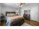 This bedroom features a ceiling fan, wood-look flooring, a dresser and access to the ensuite bath at 8218 Pine Island Rd, Clermont, FL 34711