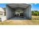 View into a large carport, perfect for protecting vehicles or storing equipment from the elements at 8218 Pine Island Rd, Clermont, FL 34711