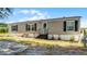 Charming single-story home with a front porch, neutral siding, black shutters, and mature plants by the front door at 8218 Pine Island Rd, Clermont, FL 34711