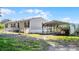 Inviting single-story home showcasing a covered parking area and a well-maintained lawn at 8218 Pine Island Rd, Clermont, FL 34711
