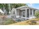 Charming exterior featuring a screened-in patio and lush surroundings, perfect for outdoor enjoyment at 8218 Pine Island Rd, Clermont, FL 34711