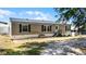 Charming single-story home with a front porch, neutral siding, and black shutters on a sunny day at 8218 Pine Island Rd, Clermont, FL 34711