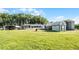 Expansive yard with multiple outbuildings and a well-maintained lawn, offering plenty of space for activities at 8218 Pine Island Rd, Clermont, FL 34711