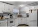 Cozy kitchen with white appliances, ample cabinetry, and charming decorative accents at 8218 Pine Island Rd, Clermont, FL 34711
