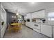 Bright kitchen featuring white appliances, dining area, and convenient laundry access at 8218 Pine Island Rd, Clermont, FL 34711