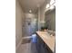 Well-lit bathroom featuring a glass door shower and gray vanity with granite countertop at 8405 Adalina Pl, Orlando, FL 32827