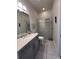 Well lit bathroom featuring gray vanity with solid surface counters and a seamless glass shower enclosure at 8405 Adalina Pl, Orlando, FL 32827