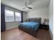 Comfortable bedroom with wood floors, ceiling fan, and two windows providing ample natural light at 8405 Adalina Pl, Orlando, FL 32827