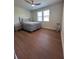 Bright bedroom featuring hardwood floors, a ceiling fan, and a window providing ample natural light at 8405 Adalina Pl, Orlando, FL 32827